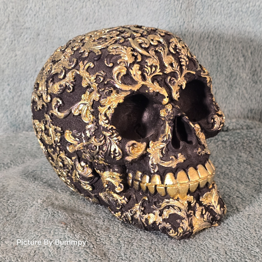 Ornate black and gold skull is a piece of gothic or Renaissance-style home decor